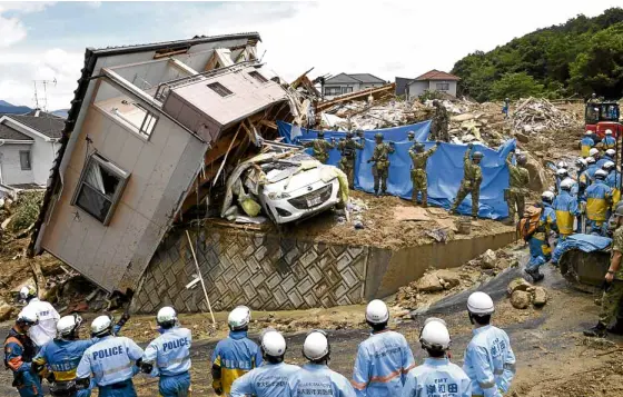  ?? —KYODOVIA REUTERS ?? LANDSLIDE IN HIROSHIMA Shattered piles of lumber mark the sites of former homes in Kumano town, Hiroshima prefecture, an area prone to landslides unleashed by torrential rains. Other homes have been tossed upside down, according to rescuers.