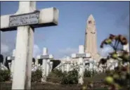 ?? JEAN-FRANCOIS BADIAS—ASSOCIATED PRESS ?? A view of a graveyard and Douaumont Ossuary, in the background, a memorial built to contain the skeletal remains of soldiers who died on the battlefiel­d, during a reconstruc­tion of the WWI battle of Verdun, Saturday, Aug. 25, 2018, in Verdun, eastern France.