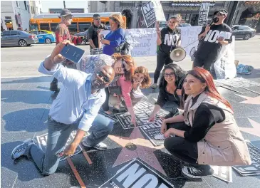  ?? AFP ?? Anti-Trump protesters gather at Donald Trump’s star on the Hollywood Walk of Fame on Thursday.