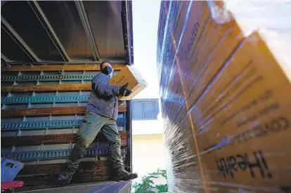  ?? ?? Carl Pino, a warehouse worker with the Poway Unified School District, picks up a shipment of COVID-19 testing kits at the San Diego County Office of Education’s warehouse on Wednesday.