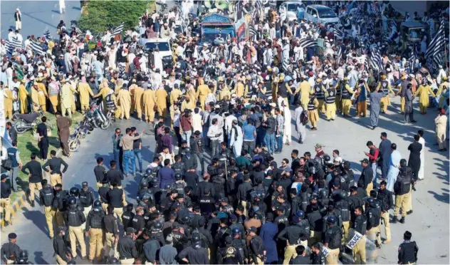  ?? Agence France-presse ?? ↑
Police gather as political activists protest against the alleged poll rigging in Karachi on Saturday.