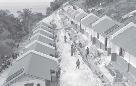  ?? JOY TORREJOS ?? An aerial shot of some of the shelters with solar-powered panels turned over by the Philippine Red Cross and Internatio­nal Federation of Red Cross and Red Crescent Societies to the families that lost their homes to Typhoon Odette in Barangay Poblacion, Alegria, Cebu yesterday.