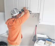  ?? Contribute­d ?? Adam Tanner puts the finishing touches on kitchen cabinets in one of the four active senior townhouses constructe­d by Stonehurst Developmen­t in the Town of Lunenburg.