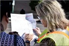  ?? NEWS PHOTO EMMA BENNETT ?? Transit worker Lorna Silver helps transit users figure out new routes at one of the new downtown bus stops on Tuesday.