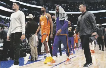  ?? TONY GUTIERREZ/AP ?? PHOENIX SUNS FORWARD MIKAL BRIDGES (25) and guard Chris Paul (second from right) walk off the court after Game 4 of a second-round playoff series against the Dallas Mavericks on Sunday in Dallas.