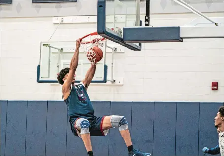  ?? PHOTO COURTESY OF UCONN ATHLETICS ?? UConn freshman Andre Jackson goes up for a dunk during the Huskies’ first practice on Friday in Storrs.