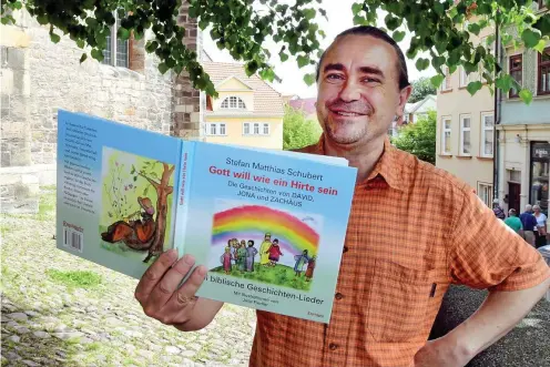  ?? FOTO: HANS-PETER STADERMANN ?? Pfarrer Stefan Matthias Schubert präsentier­t sein neues Kinder-lieder-bilder-buch.