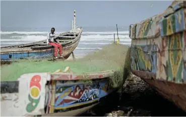  ?? /Reuters ?? Rickety boats: Fisherman Birane Mbaye, one of the survivors of a disastrous attempt to reach Spain in 2023, sits on a pirogue at the shore of Fass Boye, Senegal.