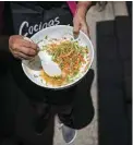  ?? ?? A woman prepares food using the peels, leaves and stems of vegetables and fruits.