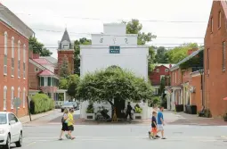  ?? PATRICK SEMANSKY/AP 2014 ?? Strollers cross a street in Shepherdst­own, W.Va., in the state’s Eastern Panhandle. Just over an hour from Washington, the region is the state’s fastest growing.