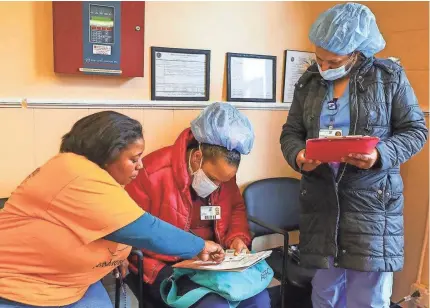  ?? ALYSSA STONE/USA TODAY NETWORK ?? Malika Jamal helps Good Samaritan Hospital staff members Cleusa Cordozo and Fernanda Ortiz fill out paperwork for child care at Agape Child Care and Family Life Center in Brockton, Mass., in March.