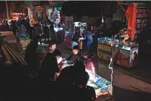  ?? AFP ?? ■ Shopkeeper­s sit at a market during a nationwide power outage, in Islamabad, on Monday.