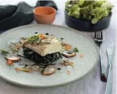  ??  ?? Top: an aerial view of Daydream Island. Left: crispy-skin Bowen coral trout with squid ink linguine, smoked crocodile and Australian caviar salad, served at Inkstone Kitchen and Bar.