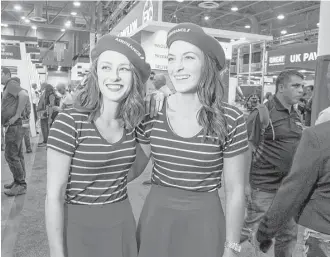  ?? Gary Fountain photos Sarah Grimes, left, and Rachael Reed dress with a French accent for work at the Air France and KLM booth. OTC attracts vendors from all over the world, and native dress can set them apart. ??