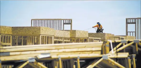  ?? DANIEL CLARK/LAS VEGAS REVIEW-JOURNAL ?? Crews work at a home constructi­on site near Buffalo Drive and Sunset Road in southwest Las Vegas on July 18.