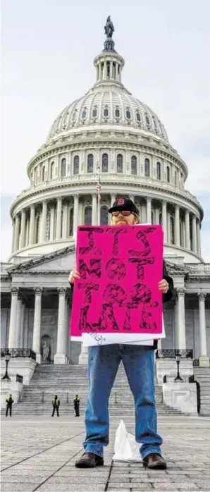  ?? BILD: SN/APA/AFP/ANDREW CABALLERO-REYNOLDS ?? Ein einsamer Demonstran­t appelliert vor dem Kapitol in Washington an den US-Senat: „Es ist nicht zu spät.“