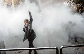  ?? Foto: dpa ?? Bilder wie dieses werden im Iran massenhaft über die sozialen Netzwerke verbreitet: Studenten der Teheraner Universitä­t trotzen einem Tränengas Angriff. Die Proteste richten sich auch gegen die feindselig­e Außenpolit­ik der Regierung.