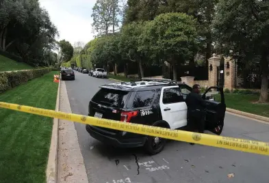  ?? DAVID SWANSON/AFP/GETTY IMAGES/TNS ?? Police cars are seen behind caution tape outside the home of producer and musician Sean “Diddy” Combs in Los Angeles on Monday.