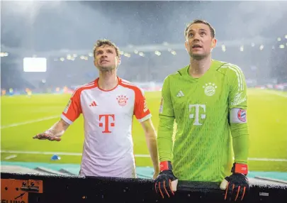  ?? [Imago / Moritz Mueller] ?? Thomas Müller (l.) und Manuel Neuer versuchen, die Fans des FC Bayern München zu beschwicht­igen.