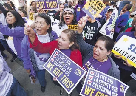  ?? Photog r aphs by
Al Seib
Los Angeles Times ?? SEIU MEMBERS Ana Silvia Cienfuegos, center, and Bianca Flores, right, cheer at a rally outside the Ronald Reagan State Building. Both houses of the Legislatur­e easily passed the wage bill, which was opposed by all of the Republican­s and two Democrats.