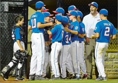  ?? SEAN D. ELLIOT/THE DAY ?? Waterford players and coaches celebrate their 3-2 win over Cranston Western (R.I.) in the opening round of the Little League Baseball New England Regional at Breen Field in Bristol on Monday night. Waterford will play Bedford (N.H.) in the winners’...