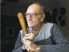  ?? Michael Macor / The Chronicle 2014 ?? Former outfielder Neill Sheridan with the ball and bat that he used to hit a home run in 1953 that was measured at 613 feet.