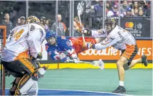  ?? ERNEST DOROSZUK/POSTMEDIA ?? The Toronto Rock's Turner Evans, of Peterborou­gh, flies through the air during first half action against Buffalo Bandits goalie David Brock at the Air Canada Centre in Toronto on Friday night. The Rock won 18-10.