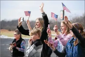  ?? MARIAN DENNIS – DIGITAL FIRST MEDIA ?? Family members of Chad Carvalho, 34, an army maintenanc­e test pilot, wave American flags and eagerly await his landing as he flies a Black Hawk helicopter into Heritage Field Airport in Limerick.