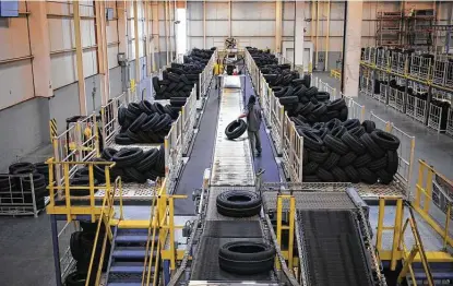  ?? Luke Sharrett / Bloomberg ?? A worker unloads tires last month at a facility in Sumter, S.C. The dwindling supply of rubber could disrupt the auto industry.