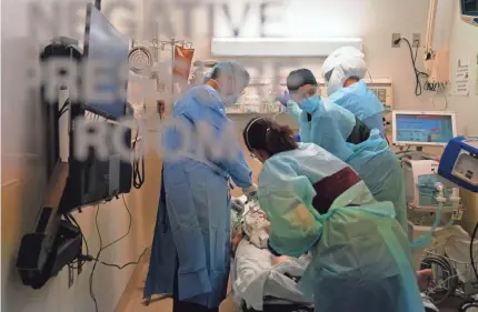  ?? JAE C. HONG/AP ?? EMT Giselle Dorgalli, second from right, looks at a monitor while performing chest compressio­ns on a patient who tested positive for the coronaviru­s in the emergency room at Providence Holy Cross Medical Center in Los Angeles.