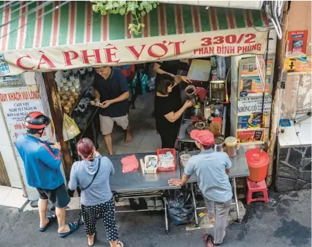  ?? ?? Patrons wait to receive their buzzy beverages in February at Ca Phe Vot in Ho Chi Minh City, Vietnam.