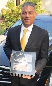  ??  ?? Chicago funeral home operator Spencer Leak Jr. holds one of the many pound cakes that were dropped off after he said he missed his favorite treat because the pandemic has canceled funeral repasts.