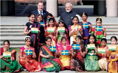  ?? AFP ?? Stefan Lofven and Narendra Modi with children outside the City Hall in Stockholm on Tuesday. —