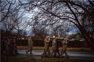  ?? Emilio Morenatti/Associated Press ?? Ukrainian soldiers carry the body of Kostiantyn Kostiuk, 35, during his funeral Saturday in Borova, near Kyiv. Kostiuk, a civilian army volunteer, was wounded during a battle Jan. 23 and died Feb. 10 in a hospital.