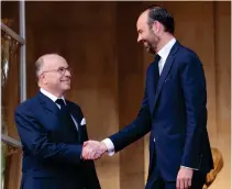  ??  ?? Edouard Philippe, right, newly appointed prime minister, is welcomed by his predecesso­r Bernard Cazeneuve in Paris on Monday during an official handover ceremony. (AFP)