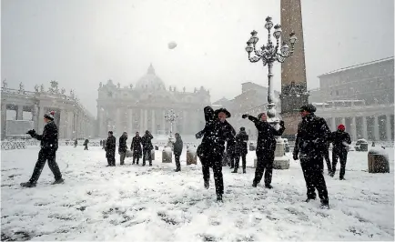  ??  ?? Shawn Roser, from Venice, Florida, a student at the North American college in Rome, throws a snowball as he plays in a snow blanketed St Peter’s Square, at the Vatican.