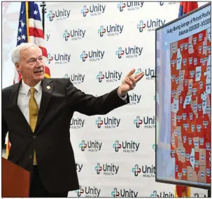  ?? (Arkansas Democrat-Gazette/Staci Vandagriff) ?? Gov. Asa Hutchinson refers to a map showing the 14-day moving average of coronaviru­s positivity percentage by county during Friday’s briefing at Unity Health in Searcy. “This is a fairly dramatic exclamatio­n point to end this week and to start the holiday weekend,” Hutchinson said of the increase in cases. More photos at arkansason­line.com/95gov/.