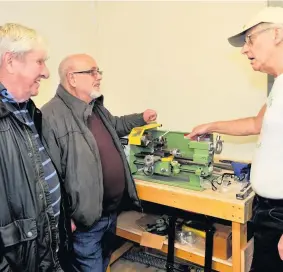  ??  ?? Shown around Derek Miller shows prospectiv­e members Billy Dick and Allan Jack a metal working lathe