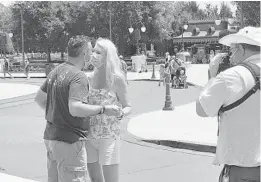  ?? ORLANDO SENTINEL ?? Gary Semel , 49, who works in IT, proposes to dental hygienist Tia Lovett, 50, at the Magic Kingdom on Saturday. They met online and bonded over their love of theme parks.