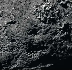  ??  ?? El monte Wright de Plutón, una elevación de unos 4 km de alto y 150 km de ancho –en el centro de la imagen–, tiene una depresión en su cima. Es probable que sea un volcán que en el pasado expulsó agua helada salpicada de amoniaco.