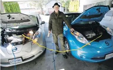  ??  ?? In this file photo from March 2016, Manfred Wissemann, president of Victoria EV Club, charges his Nissan Leaf electric vehicles at his home garage.