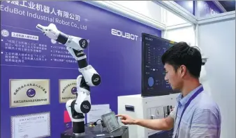  ?? XIE JIAO / XINHUA ?? A participan­t at an industrial internet conference in Chengdu, Sichuan province, operates a robotic arm.