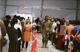  ?? David Goldman / Associated Press ?? Afghan refugees line up for food at Fort Bliss in Chaparral, N.M., in the first public look inside the U.S. base amid questions about how the government is caring for and vetting the refugees.