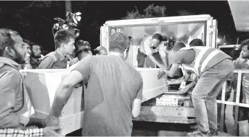  ??  ?? Airport workers help to place the body of a New Zealand mosque attack victim into a van at Hazrat Shah Jalal Internatio­nal Airport in Dhaka. — AFP photo