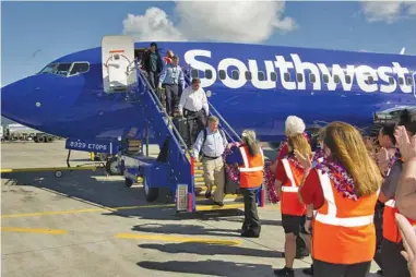  ??  ?? Iti isasanglad ti Southwest Airlines iti Honolulu, naipasabat kadagiti pasahero ti lei, kas naikaugali­an ti Hawaii a pammasangb­ay.