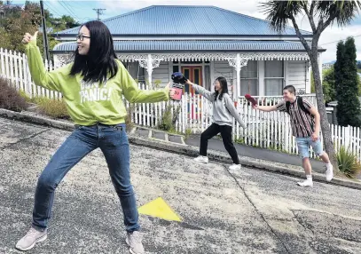  ?? PHOTO: PETER MCINTOSH ?? Leaning into learning . . . Lei Zhou (left) and Ting Chen, both of China, and Flynn Mankelow, of Oamaru, see the sights of Dunedin at Baldwin St before beginning study at Otago Polytechni­c this month.