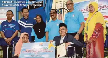  ??  ?? ABDULLAH (berkerusi roda) menerima Anugerah Lelaki Tertua di Terengganu.