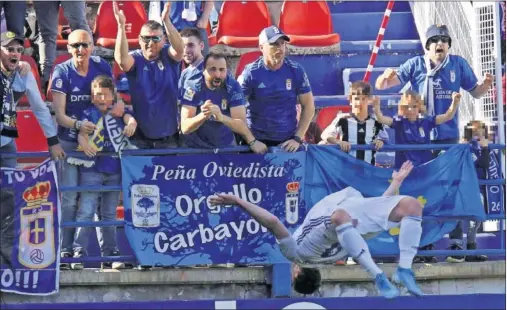  ??  ?? Rodri celebró su gol ante el Extremadur­a con esta voltereta, en la grada de los aficionado­s oviedistas en el Francisco de la Hera.