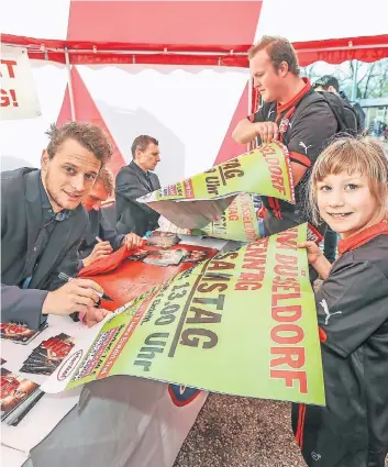  ?? FOTOS: HANS-JÜRGEN BAUER ?? Die Fortuna-Profis Julian Schauerte, Axel Bellinghau­sen und Oliver Fink (von links) erfüllen den kleinen und großen Fans beim ersten Renntag der Saison ihre Autogrammw­ünsche.