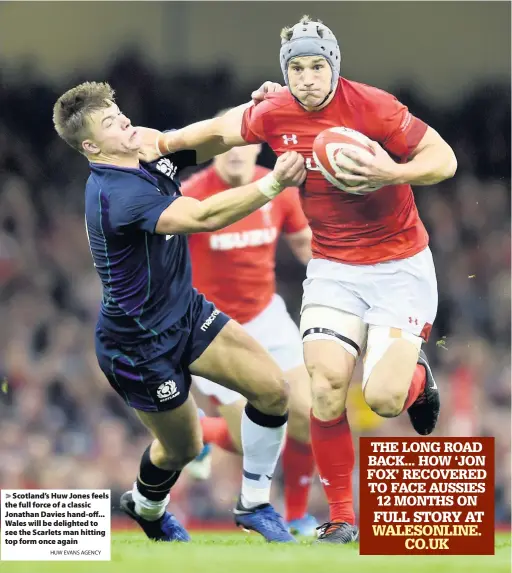  ?? HUW EVANS AGENCY ?? &gt; Scotland’s Huw Jones feels the full force of a classic Jonathan Davies hand-off... Wales will be delighted to see the Scarlets man hitting top form once again